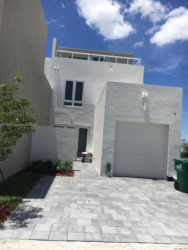 view of front facade featuring decorative driveway and stucco siding