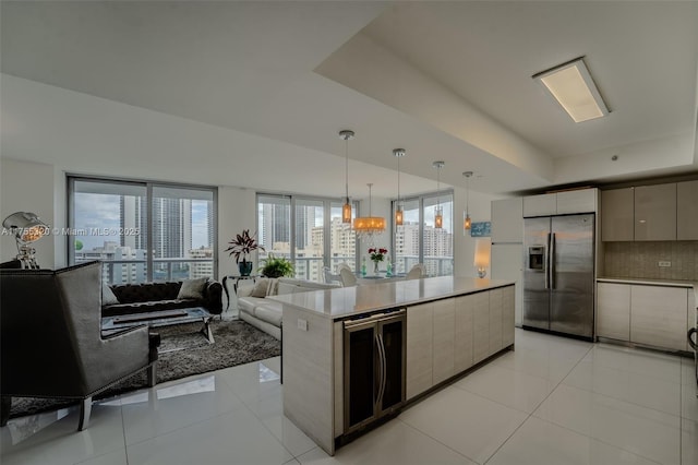 kitchen with light tile patterned floors, modern cabinets, a tray ceiling, and stainless steel refrigerator with ice dispenser