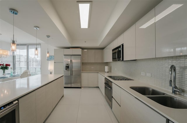 kitchen with appliances with stainless steel finishes, modern cabinets, a sink, and tasteful backsplash