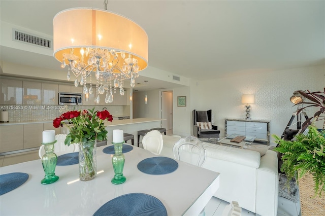 dining room featuring visible vents and a notable chandelier