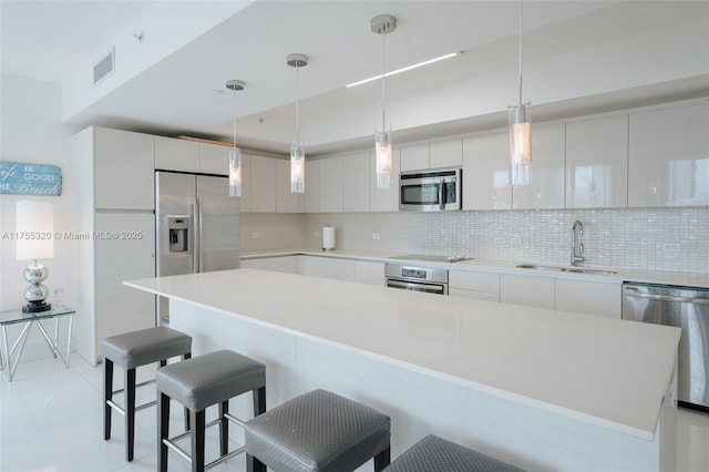 kitchen featuring a sink, visible vents, appliances with stainless steel finishes, decorative backsplash, and modern cabinets