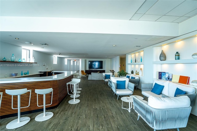 interior space with indoor wet bar, visible vents, and wood finished floors