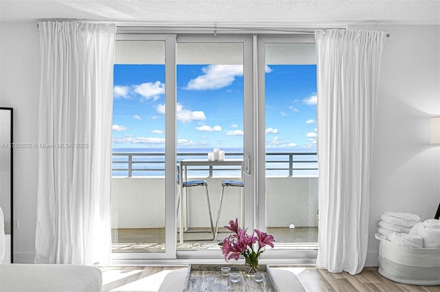 interior space featuring a textured ceiling and a water view