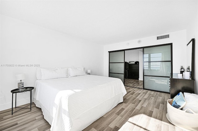 bedroom with visible vents and wood finished floors