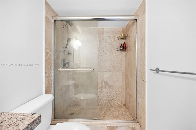 bathroom featuring a stall shower and toilet