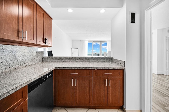 kitchen featuring light stone counters, recessed lighting, dishwashing machine, and tasteful backsplash