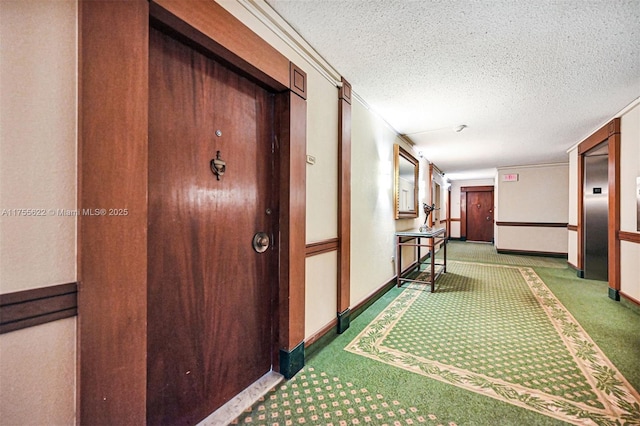 hall featuring elevator, a textured ceiling, baseboards, and carpet