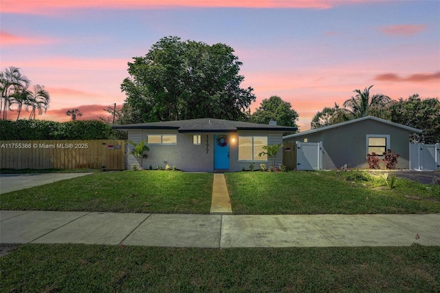 view of front of home featuring a gate, stucco siding, a yard, and fence