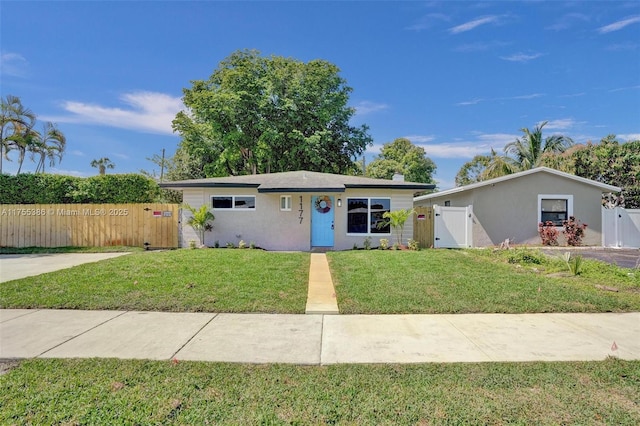 ranch-style house with a front yard, fence, a gate, and stucco siding