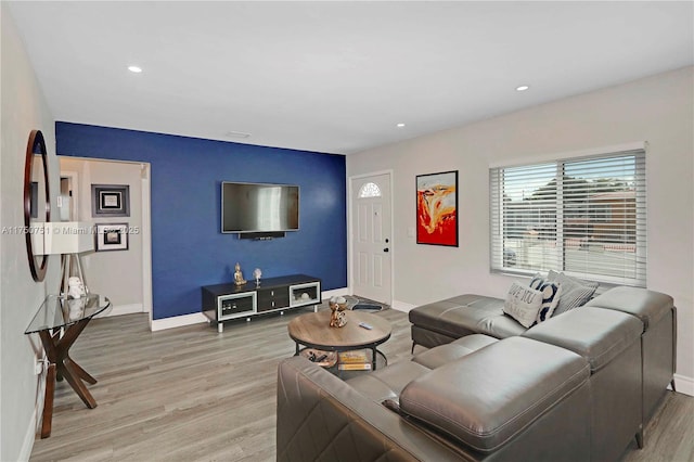 living room with light wood-style flooring, baseboards, and recessed lighting