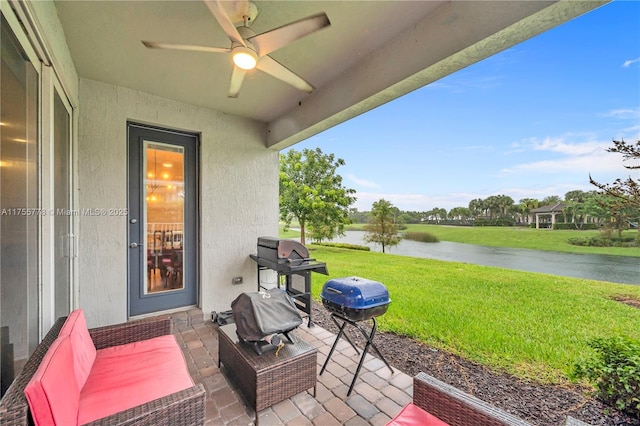 view of patio featuring a water view, ceiling fan, and area for grilling