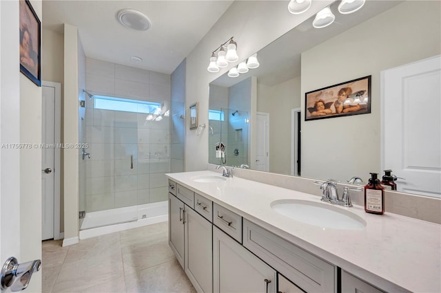 full bathroom featuring double vanity, tile patterned floors, a sink, and a shower stall