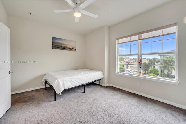 carpeted bedroom featuring a ceiling fan and baseboards