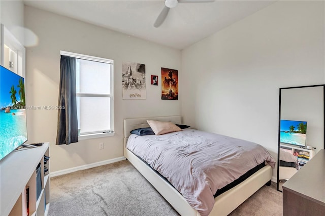 carpeted bedroom with ceiling fan and baseboards