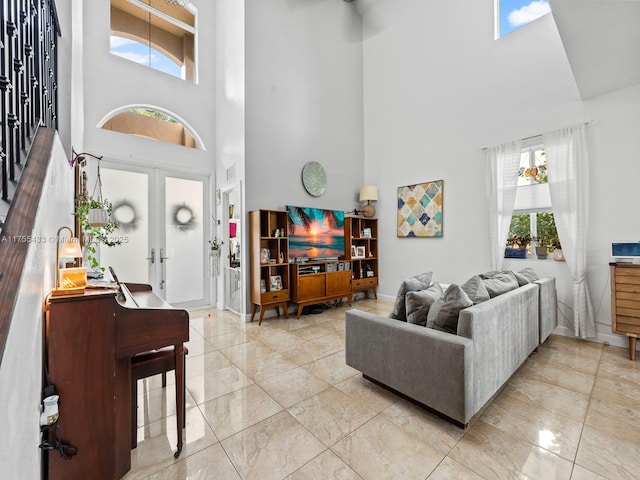 living area with french doors, plenty of natural light, and a high ceiling