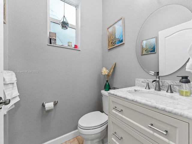 bathroom featuring tile patterned flooring, baseboards, vanity, and toilet