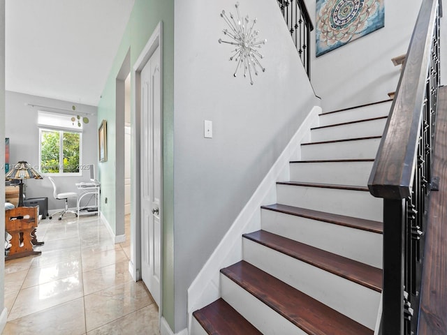 stairway with tile patterned flooring and baseboards