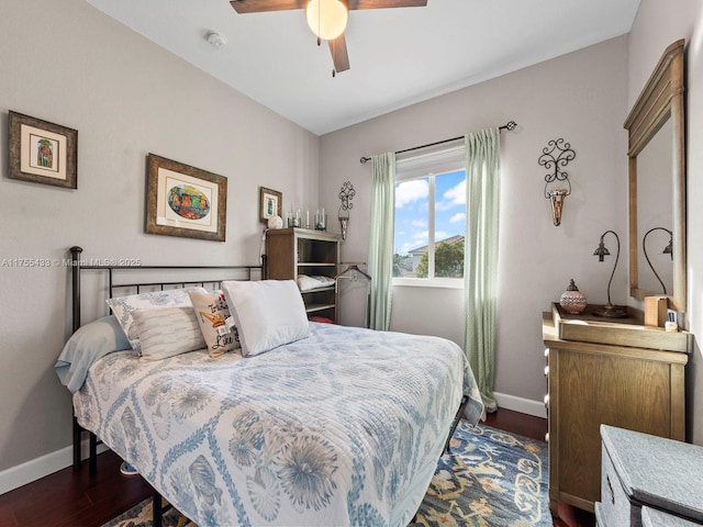 bedroom with dark wood finished floors, a ceiling fan, and baseboards