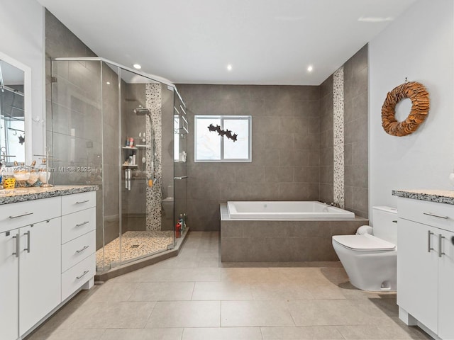 bathroom with a garden tub, toilet, vanity, a shower stall, and tile patterned flooring