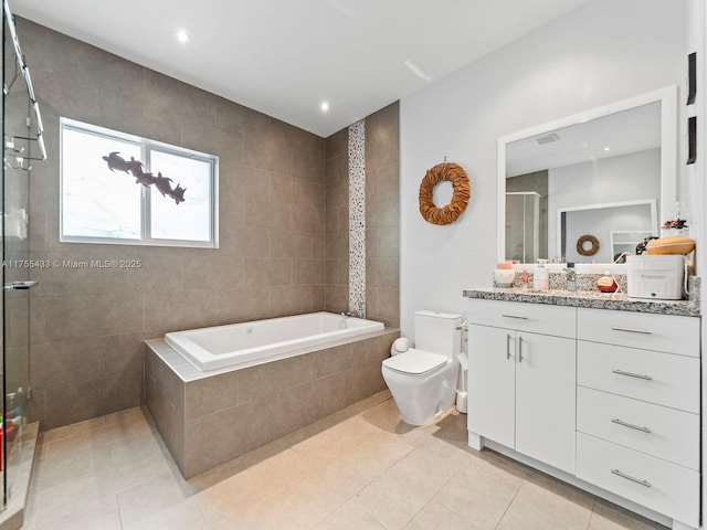 bathroom featuring a stall shower, tile patterned flooring, a garden tub, and toilet