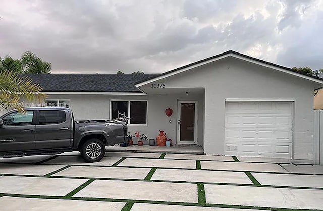 single story home featuring roof with shingles and stucco siding