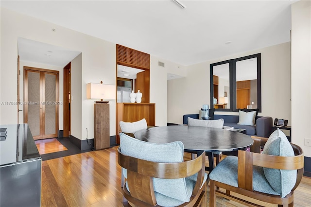 dining area with visible vents and light wood-style flooring