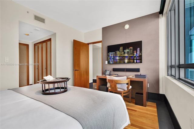 bedroom featuring visible vents and wood finished floors