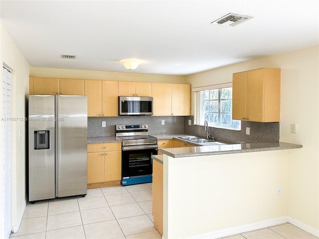 14116 SW 260th St Unit 105, Homestead, FL 33032 - kitchen featuring appliances with stainless steel finishes, light brown cabinets, a peninsula, decorative backsplash, and visible vents
