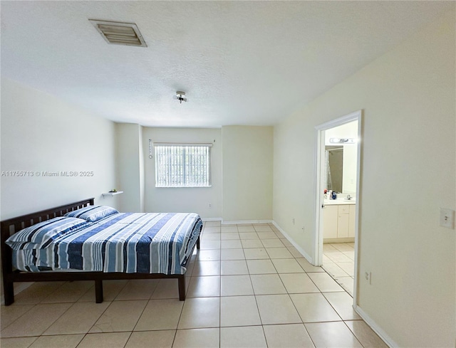 14116 SW 260th St Unit 105, Homestead, FL 33032 - bedroom with connected bathroom, baseboards, visible vents, and light tile patterned floors