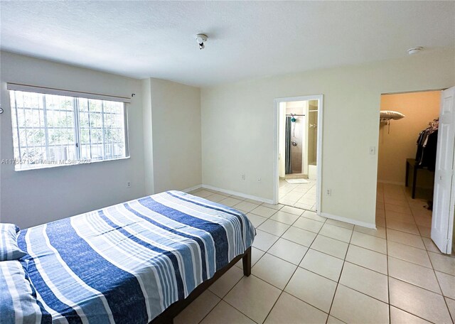 14116 SW 260th St Unit 105, Homestead, FL 33032 - bedroom featuring baseboards, a walk in closet, and light tile patterned flooring