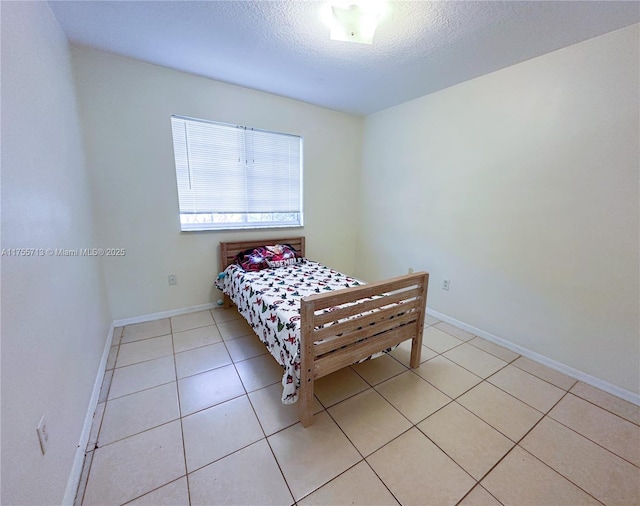 14116 SW 260th St Unit 105, Homestead, FL 33032 - bedroom featuring light tile patterned floors, baseboards, and a textured ceiling