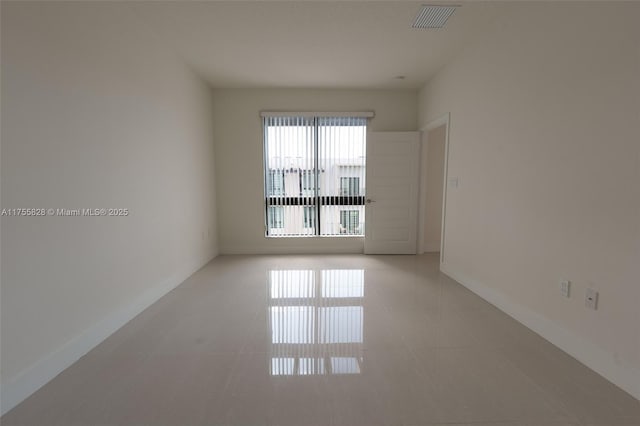 unfurnished room with light tile patterned floors, visible vents, and baseboards