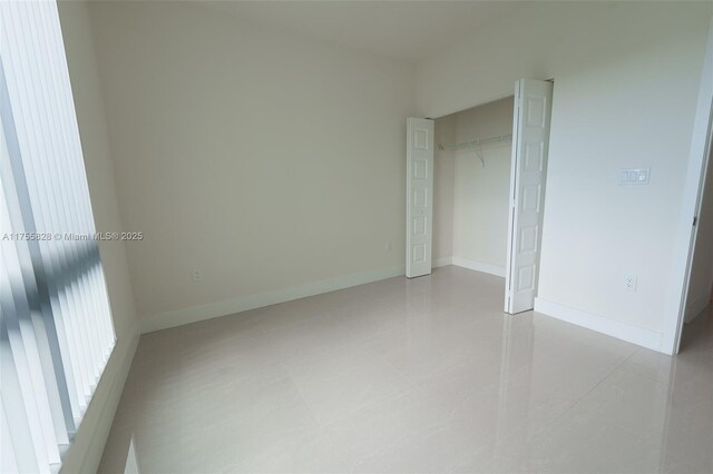 unfurnished bedroom featuring baseboards and a closet