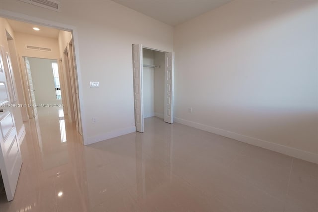 unfurnished bedroom with visible vents, baseboards, and a closet