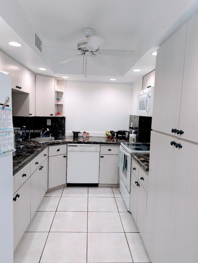 kitchen with light tile patterned floors, decorative backsplash, a ceiling fan, a sink, and white appliances