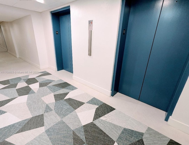 interior space with tile patterned flooring and elevator