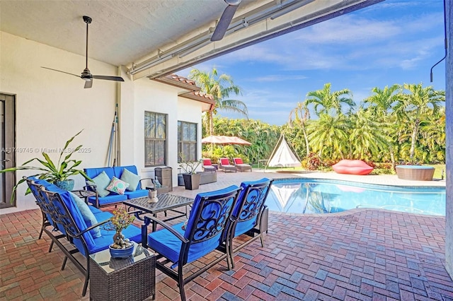 pool with a patio area, an outdoor hangout area, and a ceiling fan