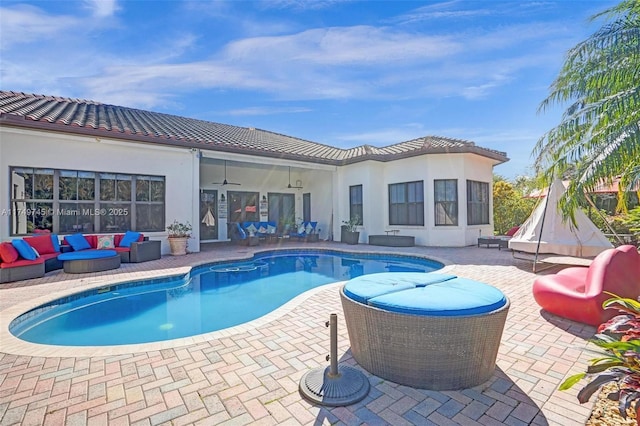 pool featuring an outdoor hangout area, a patio, and a ceiling fan