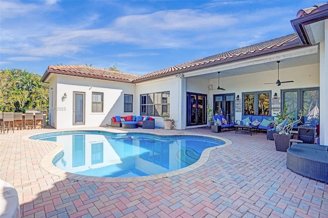 pool with a patio area, outdoor lounge area, and outdoor dry bar