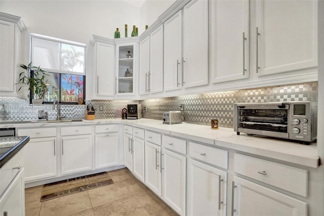 4455 Parkside Rd, Davie, FL 33328 - kitchen featuring white cabinets, tasteful backsplash, glass insert cabinets, light tile patterned floors, and light stone counters