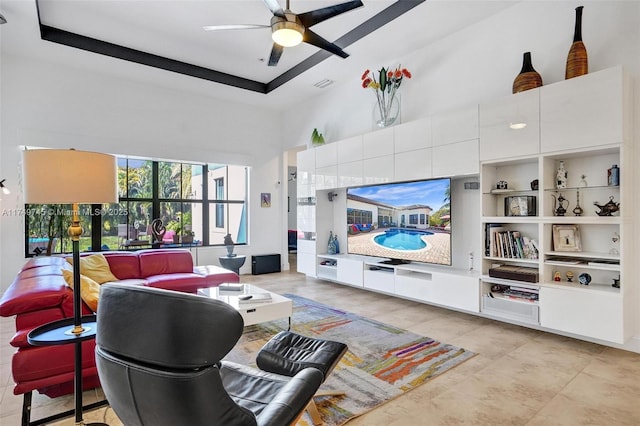 living room with a tray ceiling, a high ceiling, visible vents, and a ceiling fan