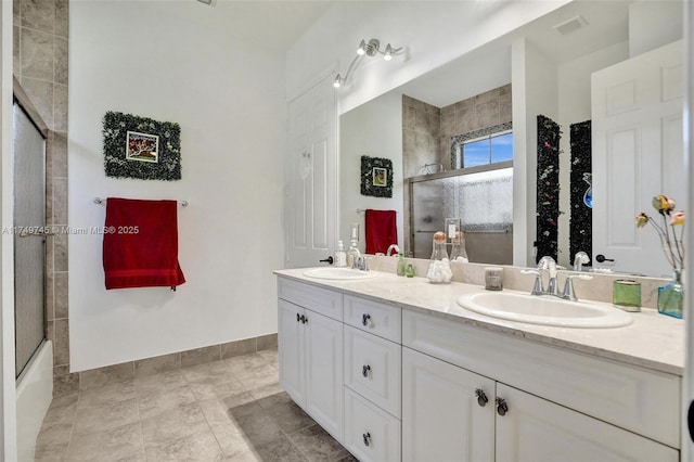 bathroom featuring visible vents, a tile shower, and a sink