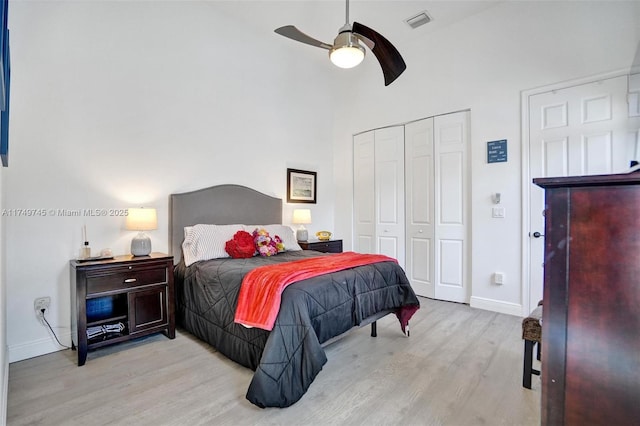 bedroom with baseboards, visible vents, ceiling fan, light wood-style floors, and a closet