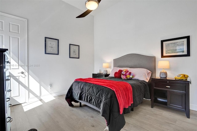 bedroom with ceiling fan, light wood-style flooring, and baseboards