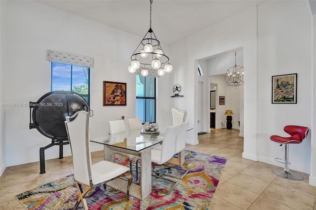 tiled dining area with a chandelier and baseboards