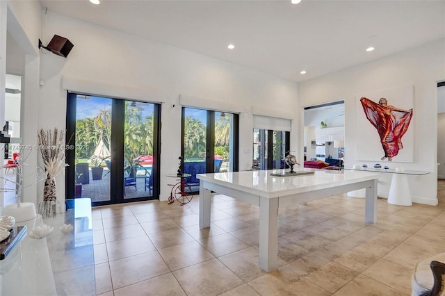 playroom with a towering ceiling, recessed lighting, light tile patterned flooring, and french doors