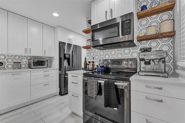 kitchen featuring appliances with stainless steel finishes, tasteful backsplash, white cabinetry, and open shelves