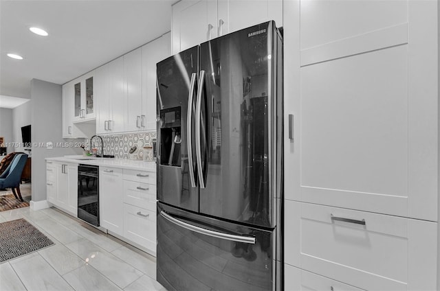 kitchen with beverage cooler, light countertops, stainless steel refrigerator with ice dispenser, and white cabinets