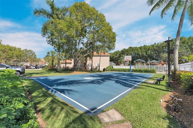 view of basketball court with community basketball court, fence, and a yard