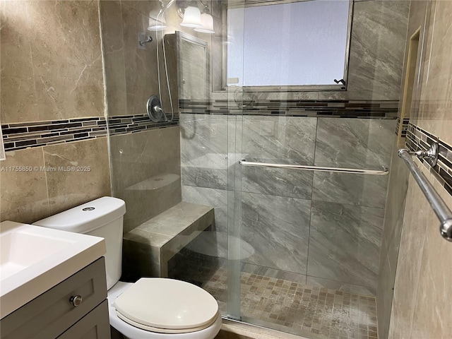 full bathroom featuring a stall shower, vanity, and toilet